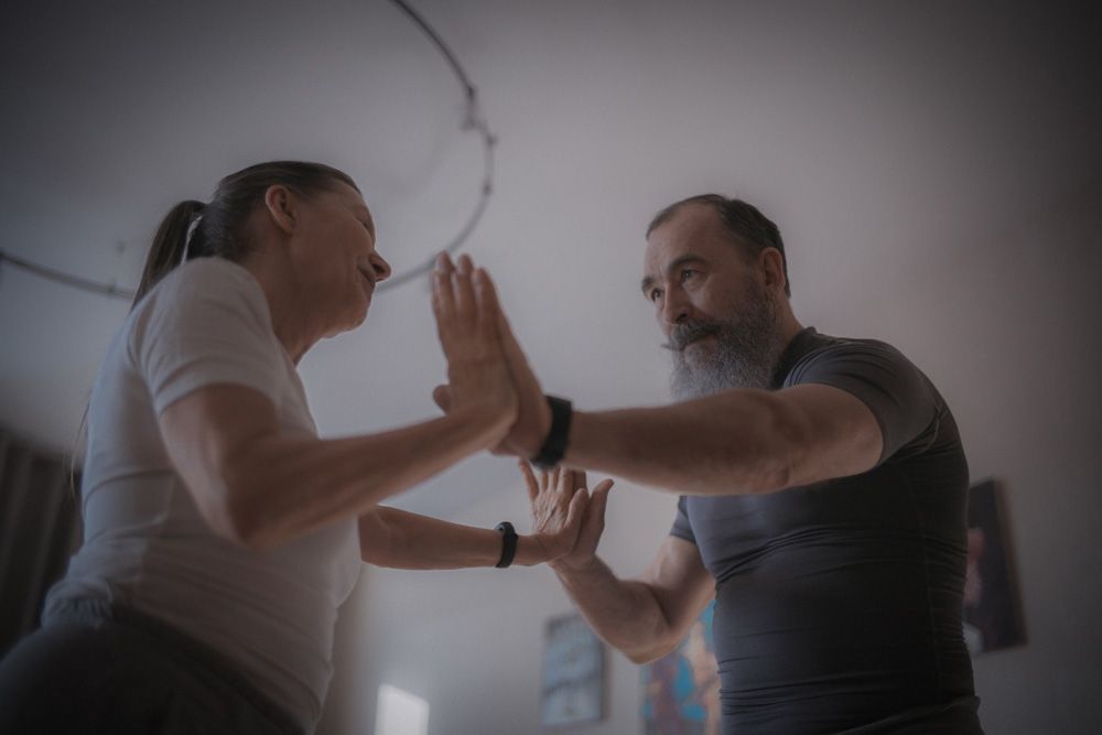 Man and woman facing each other with their palms touching