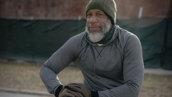 Black man exercising on outdoor bench